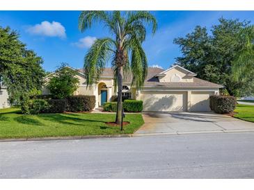 Charming single-story home with a well-manicured lawn, mature landscaping, and an attached two-car garage at 305 Grand Reserve Dr, Davenport, FL 33837
