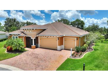 Stunning home exterior with a tile roof, brick driveway and manicured lawn at 346 Treviso Dr, Kissimmee, FL 34759