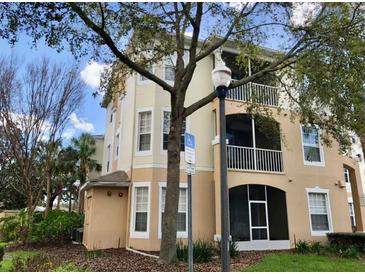 Three-story building featuring private screened balconies and lush landscaping around the property at 6100 Stevenson Dr # 202, Orlando, FL 32835