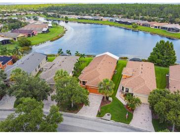 Stunning aerial view of waterfront homes with lush landscaping and serene lake views at 925 Grand Canal Dr, Poinciana, FL 34759