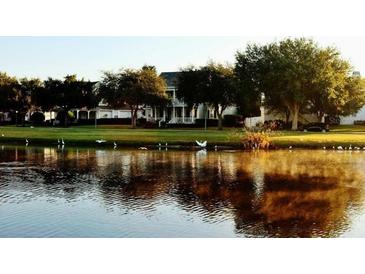 Scenic community view with a lake surrounded by lush greenery and an elegant home in the background at 934 Westpark Dr, Celebration, FL 34747