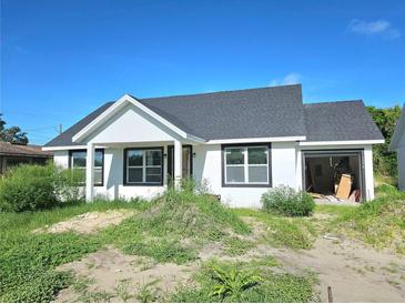 Charming single-story home featuring a modern design with an open garage and unfinished landscaping at 1236 N Virginia Ave, Lakeland, FL 33805