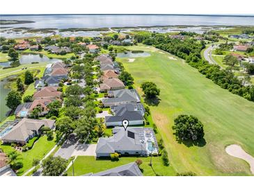 Beautiful aerial view of a home on a golf course with a pool and lake in the background at 1810 Lee Janzen Dr, Kissimmee, FL 34744