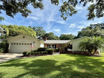 Charming one-story home featuring lush landscaping and a well-manicured lawn at 1921 Japonica Rd, Winter Park, FL 32792