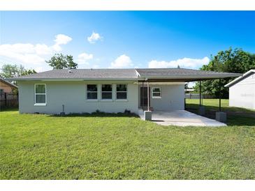 This backyard features a lush lawn and a cozy covered patio, perfect for outdoor entertaining at 2221 Wakulla Way, Orlando, FL 32839