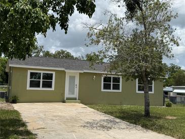 Charming home with an olive drab exterior, front yard, and concrete driveway leading up to the white front door at 2549 Olive Ave, Lake Wales, FL 33898
