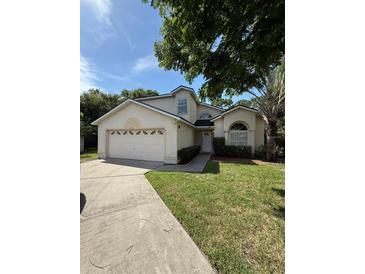 Charming two-story home featuring a well-manicured lawn and attached two-car garage at 2833 Falling Tree Cir, Orlando, FL 32837