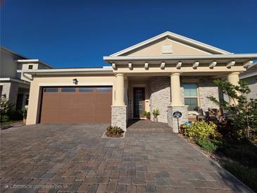 Charming single-Gathering home featuring a two-car garage, stone accents, and a welcoming covered entry at 2853 Willowseed Ln, St Cloud, FL 34772