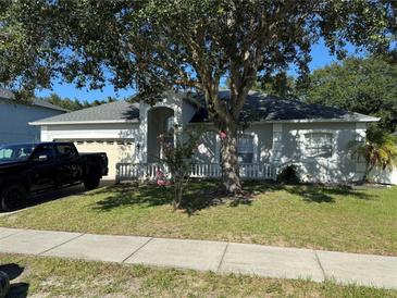Charming single-Gathering home featuring an attached garage, beautiful landscaping, and a well-manicured lawn at 478 Acacia Tree Way, Kissimmee, FL 34758
