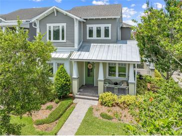 Charming two-story home with landscaped yard, covered porch, and inviting green door at 9121 Laureate Blvd, Orlando, FL 32827