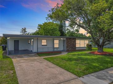 Charming single-story home featuring a well-manicured lawn and a brick accent wall at 5312 Kingswood Dr, Orlando, FL 32810