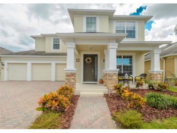 Charming two-story home featuring a welcoming front porch, three-car garage, and well-maintained landscaping at 7971 Brofield Ave, Windermere, FL 34786