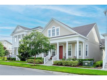 Inviting home featuring a charming front porch, well-maintained landscaping, and a freshly cut lawn at 1855 Treasure Cv, Kissimmee, FL 34747
