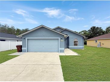 Charming single-story home features a well-manicured lawn, a two-car garage, and a classic facade at 2444 Oak Mill Dr, Kissimmee, FL 34744