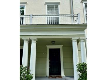 Inviting front entrance featuring stately white columns, a balcony, and dark-colored front door at 267 Goldenrain Dr # 30, Celebration, FL 34747