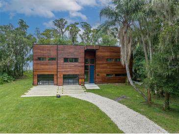 Stunning modern home with wood facade, garage, and manicured lawn, radiating curb appeal at 3807 S Semoran Blvd, Orlando, FL 32822