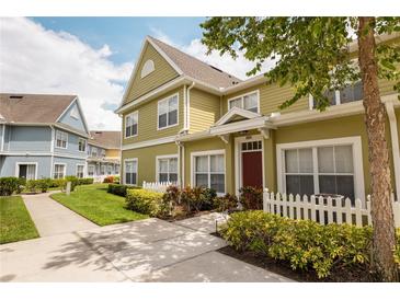 Charming townhome with landscaped front yard and colorful exterior, enhanced by a manicured lawn and inviting walkway at 4008 San Sebastian Dr # 105, Kissimmee, FL 34741