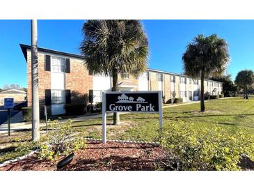 Grove Park apartments with landscaped grounds and a community sign, all under a clear blue sky at 5325 Curry Ford Rd # D203, Orlando, FL 32812
