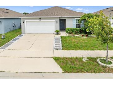 Charming single-story home featuring a well-manicured lawn and a welcoming, neutral-toned facade at 739 Jefferson, Davenport, FL 33837