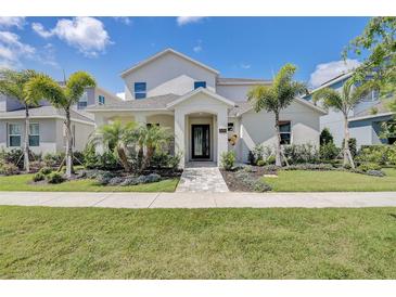 Stunning two-story home with lush landscaping and inviting entrance in a tropical setting at 7458 Gathering Dr, Kissimmee, FL 34747