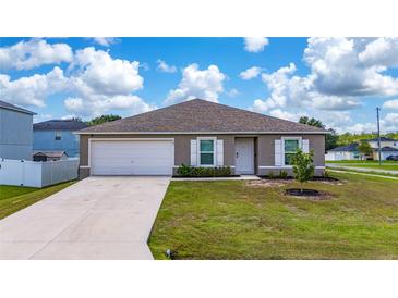 Charming single-story home featuring a well-manicured lawn and attached two-car garage at 761 Parrot Ct, Kissimmee, FL 34759