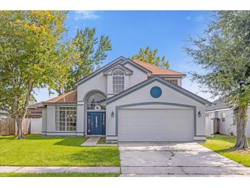 Charming two-story home with a well-manicured lawn and a two car garage at 10957 Norcross Cir, Orlando, FL 32825
