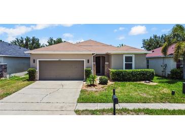 Charming single Gathering home featuring a two-car garage and well manicured lawn with shrubbery at 2829 Shelburne Way, St Cloud, FL 34772