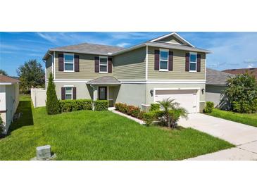 Charming two-story home with a well-manicured lawn, two-car garage, and inviting front entrance at 454 Sunfish Dr, Winter Haven, FL 33881