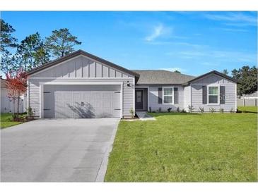 Charming single-story home featuring a well-manicured lawn and a two-car garage at 2645 Sw 163Rd Pl, Ocala, FL 34473