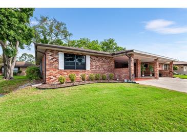 Brick ranch home with carport and well-manicured lawn at 565 Lake Mystic Ln, Lakeland, FL 33813