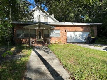 Charming single Gathering home featuring a brick exterior, front porch and an attached garage at 1219 Dixie Dr, Auburndale, FL 33823