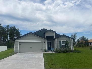 Charming single-story home with a well-maintained lawn and attached two-car garage at 4423 Sw 171St Pl, Ocala, FL 34473