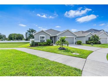 One-story home with gray siding, two-car garage, and landscaped lawn at 6388 Gardner Dr, Lakeland, FL 33813