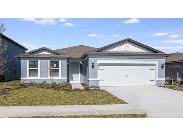 Gray house with two-car garage and landscaped lawn at 6826 Sw 90Th Loop, Ocala, FL 34476