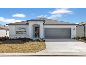 One-story home with gray garage door and landscaping at 6829 Sw 90Th Loop, Ocala, FL 34476