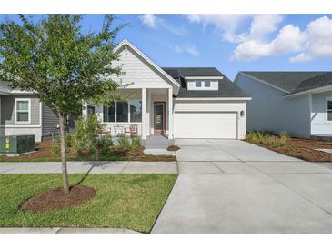 Charming single-story home with a well-manicured lawn, covered porch, and a two-car garage at 3062 Bootlace Way, St Cloud, FL 34771