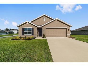 Charming single-Gathering home with a manicured lawn, neat flowerbeds, and a two-car garage at 684 Se 65Th Ter, Ocala, FL 34472