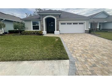 One-story home with a two-car garage, and landscaped lawn at 7987 Lake James Blvd, Lakeland, FL 33810