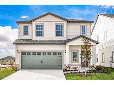 Two-story house with gray garage door and landscaping at 3728 Bergamot St, Lake Alfred, FL 33850