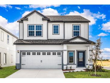 Two-story house with white siding, gray accents, and a two-car garage at 3744 Bergamot St, Lake Alfred, FL 33850