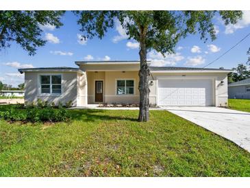 Inviting single-story home with a well-maintained lawn, attached two-car garage, and classic front door at 2511 Avenue E Sw, Winter Haven, FL 33880