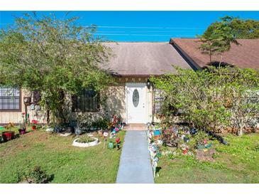 Front view of a charming condo with a well-maintained lawn and walkway at 3017 Jon Jon Ct, Orlando, FL 32822