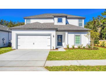 Charming two-story home with a well-maintained lawn, attached garage and modern architectural details at 13490 Leaping Water Way, Astatula, FL 34705