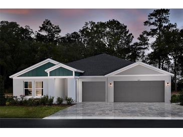 Two-story home with gray and green exterior, two-car garage, and landscaped yard at 6013 Sw 96Th Pl, Ocala, FL 34476