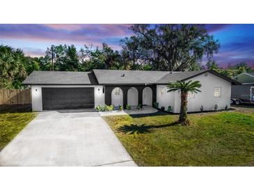 Updated single-story home with modern gray garage door, and a manicured lawn at 1309 Buccaneer Ave, Deltona, FL 32725