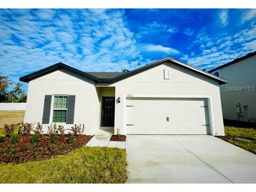 One story home with attached garage and landscaping at 13454 Leaping Water Way, Astatula, FL 34705