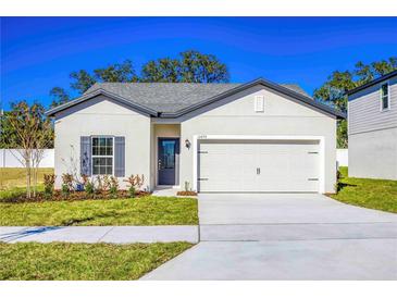 Charming single-story home featuring a well-manicured lawn and a two-car garage at 13454 Leaping Water Way, Astatula, FL 34705