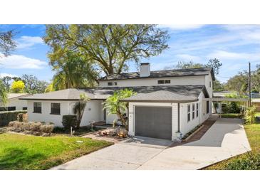 Charming two-story home features a spacious driveway, a gray garage door, and a well-manicured lawn at 3203 S Polk Ave, Lakeland, FL 33803