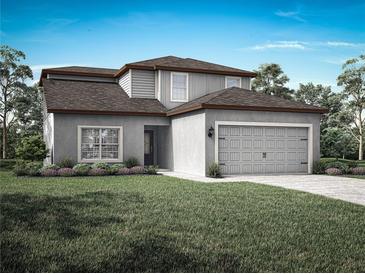 Charming two-story home features a gray exterior, a two-car garage and beautifully manicured lawn at 13446 Leaping Water Way, Astatula, FL 34705