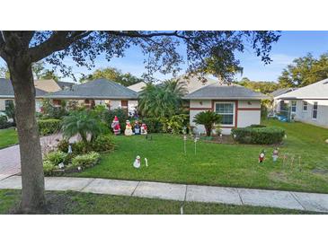 Charming single-story home with well-manicured lawn, festive holiday decorations, and mature landscaping at 1694 Town Park Dr, Port Orange, FL 32129